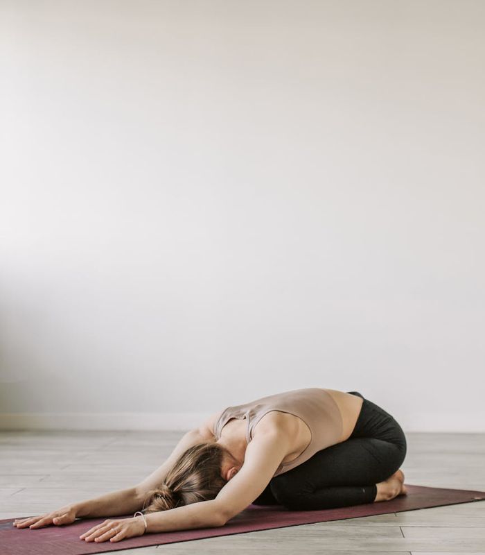 Person practicing mindful yoga movements in a dark studio